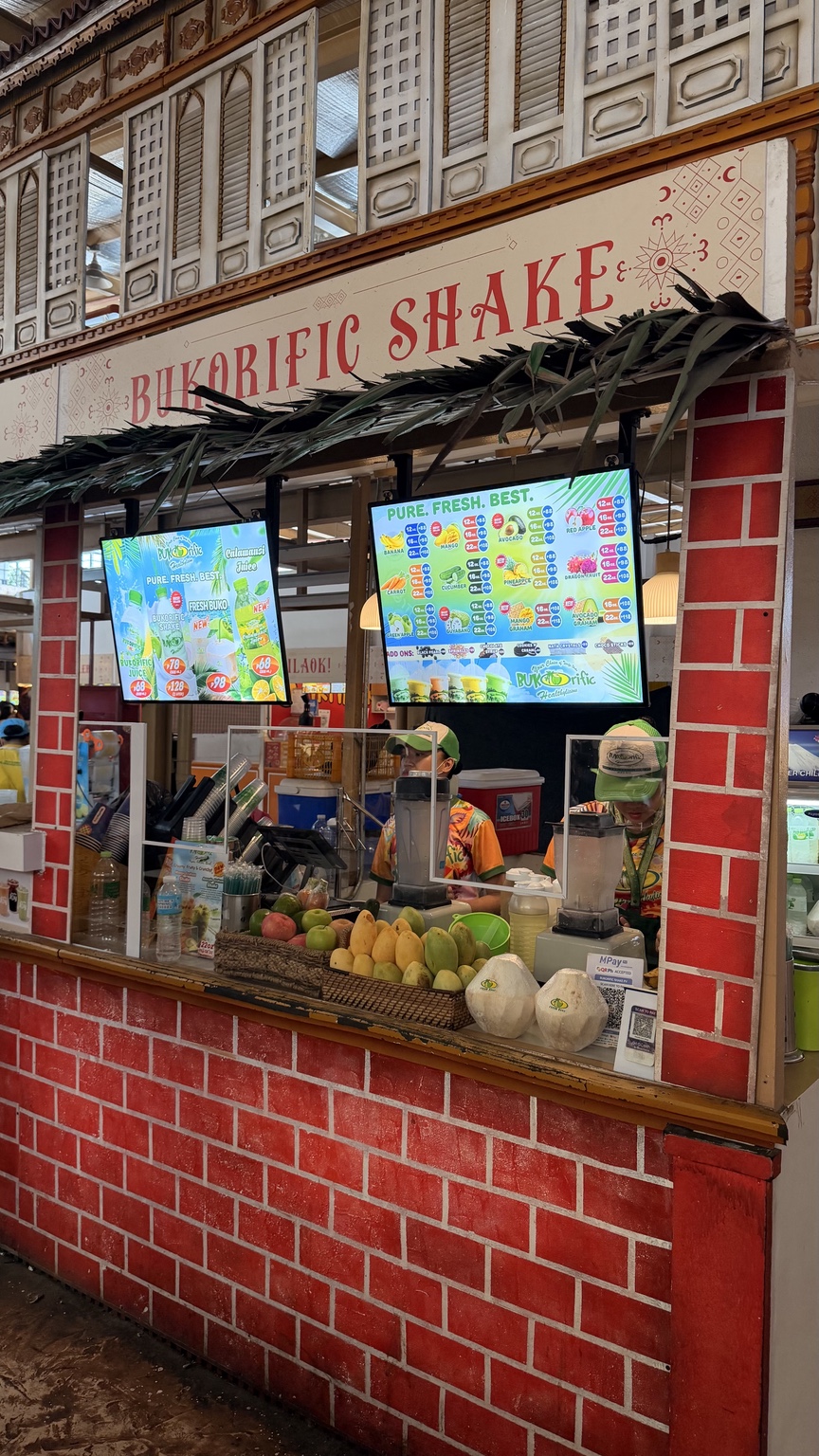 Puso Village Bukorific stall with fresh fruit and menu boards